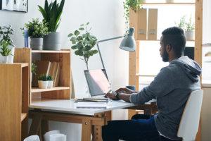 Man working at desk on laptop at home